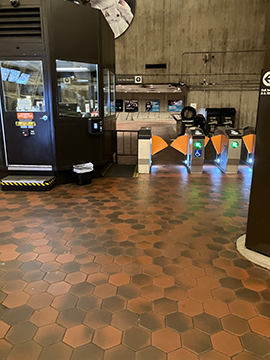 A picture of the faregates at the D St and 7th St exit. The ADA faregate is closest to the station manager