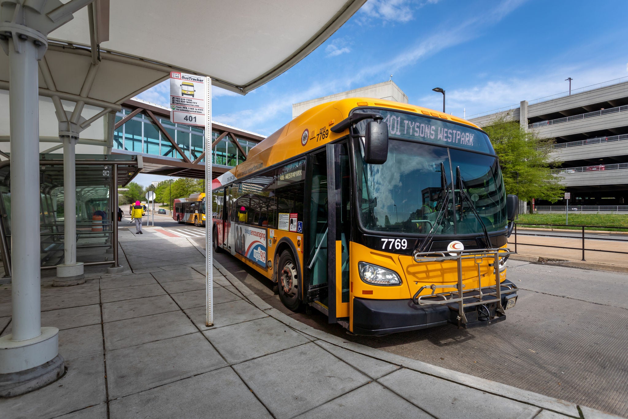 Image of bright yellow Fairfax Connector bus serving Route 401 at a bus bay.