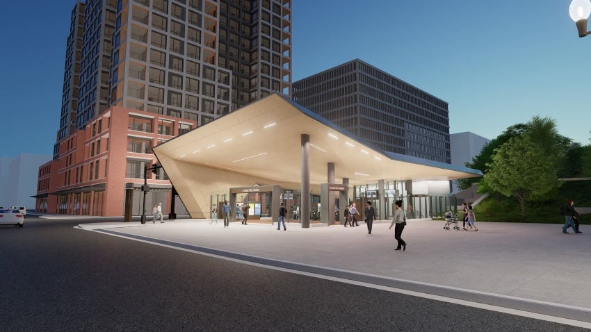 Nighttime architectural rendering of the proposed Crystal City Metro Station East Entrance pavilion, shown from Crystal Drive looking towards the southwest. Interior of entrance pavilion roof is made of wooden panels with strips of lighting, partially supported by metal columns. Human figures appearing of various races, genders, and ages are depicted walking into, out of, and around the station entrance.