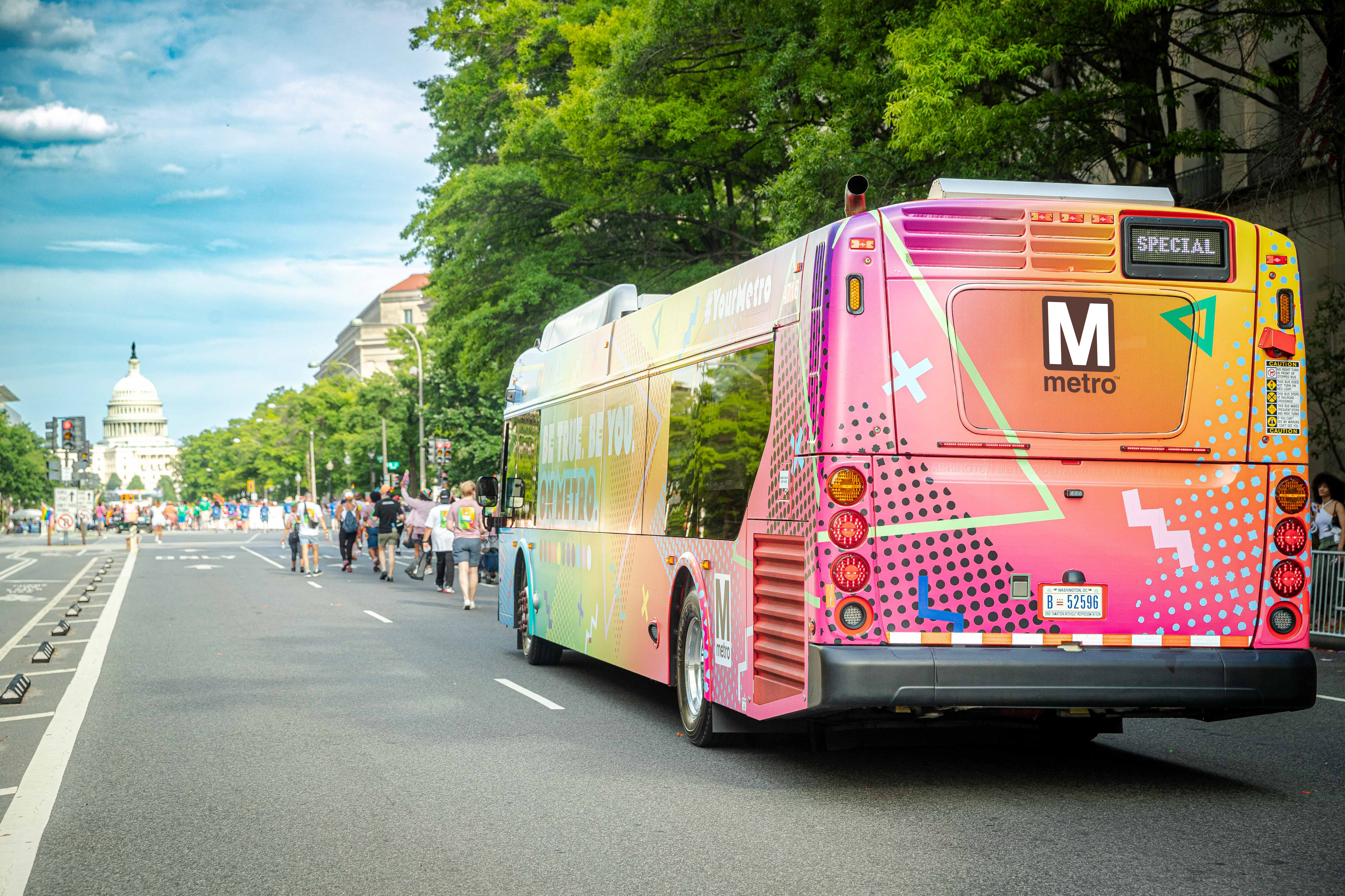 Colorful Metro Bus in a parade with the US Capitol Building in the background.